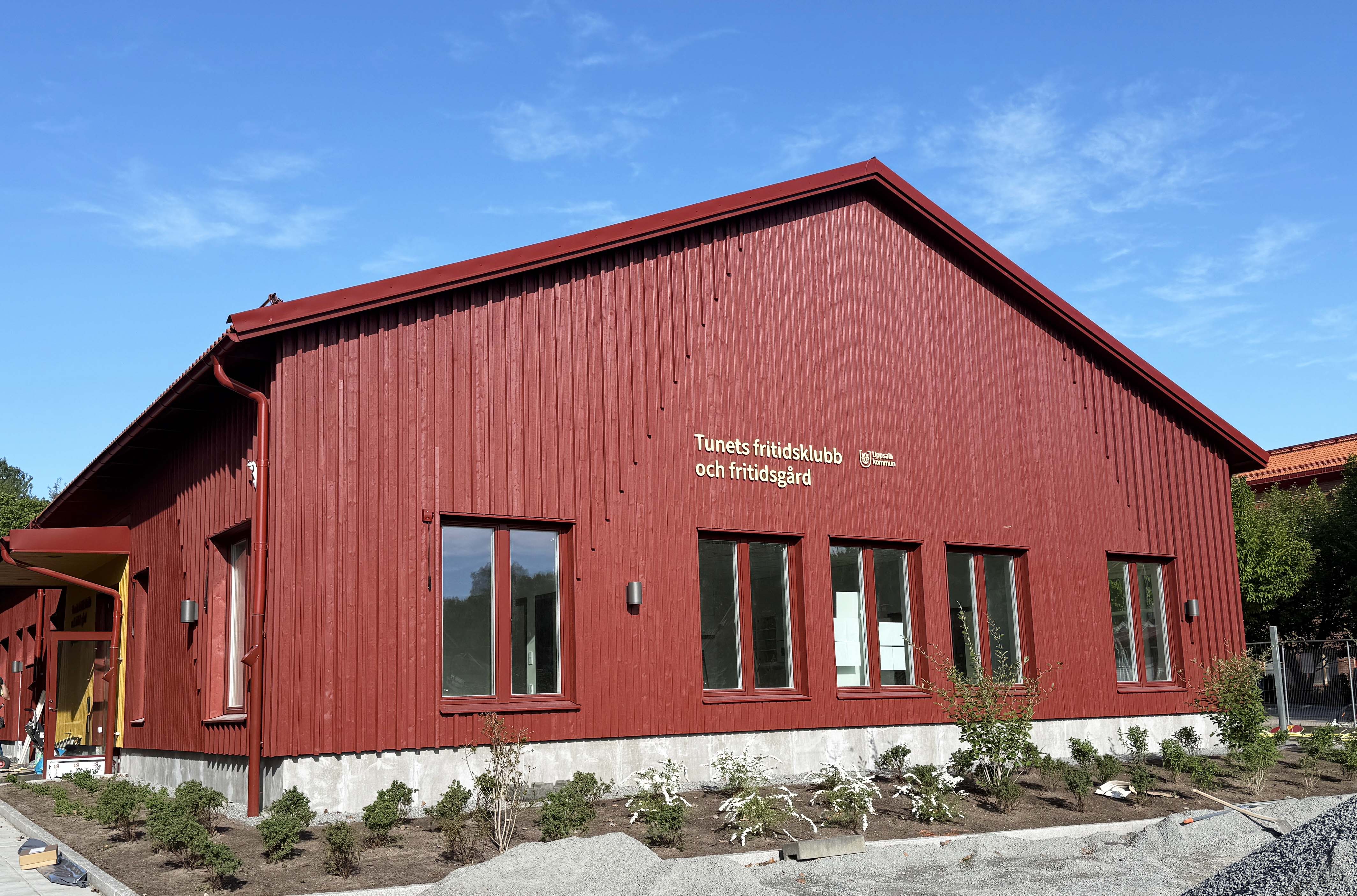 Nybyggt skolhus med röd träfasad.