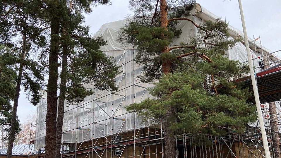 Skola med byggnadsställning och skyddspresenning.
