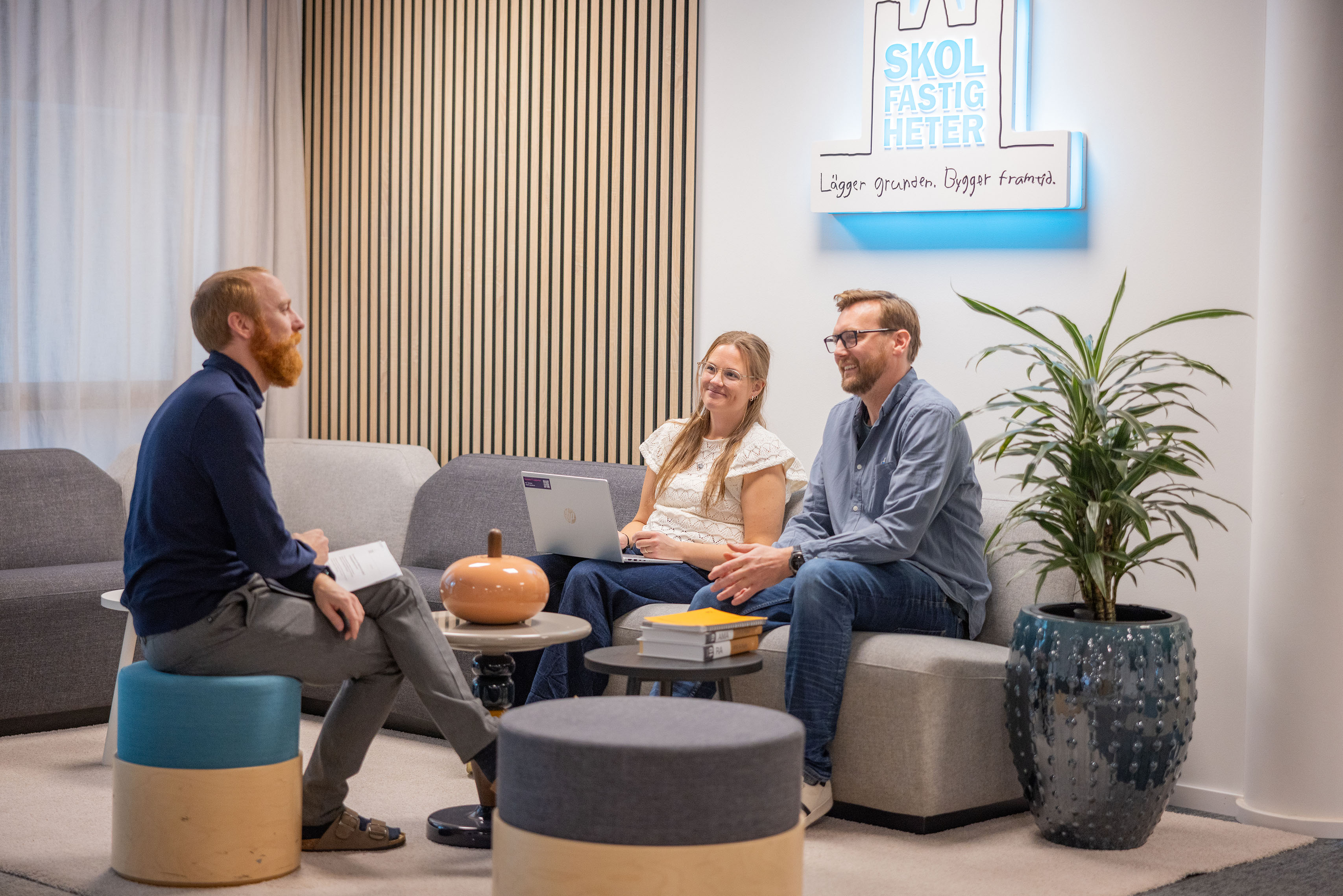 Tre kollegor som sitter i soffa och pratar