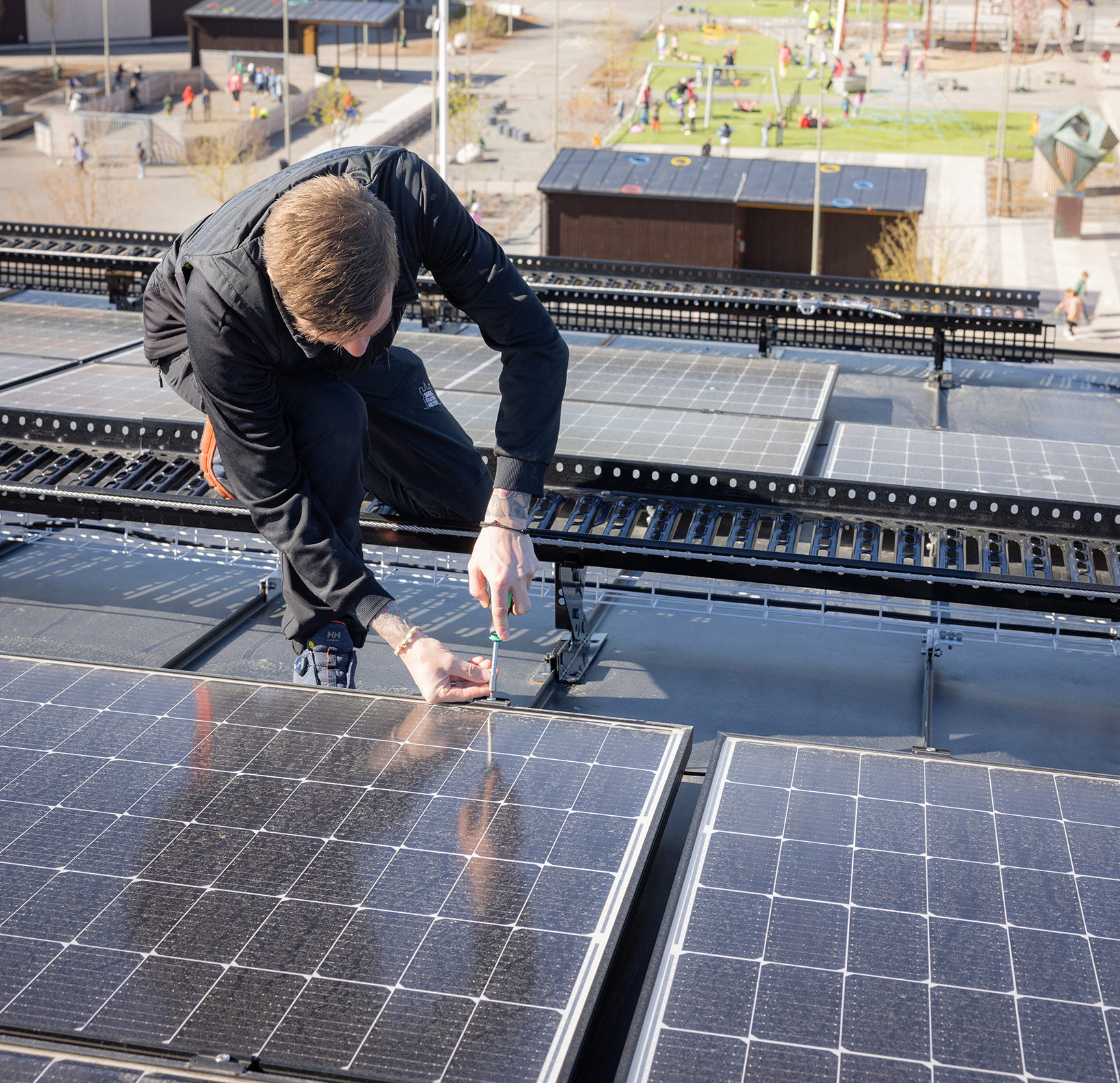 Drifttekniker skruvar på en solcellsanläggning