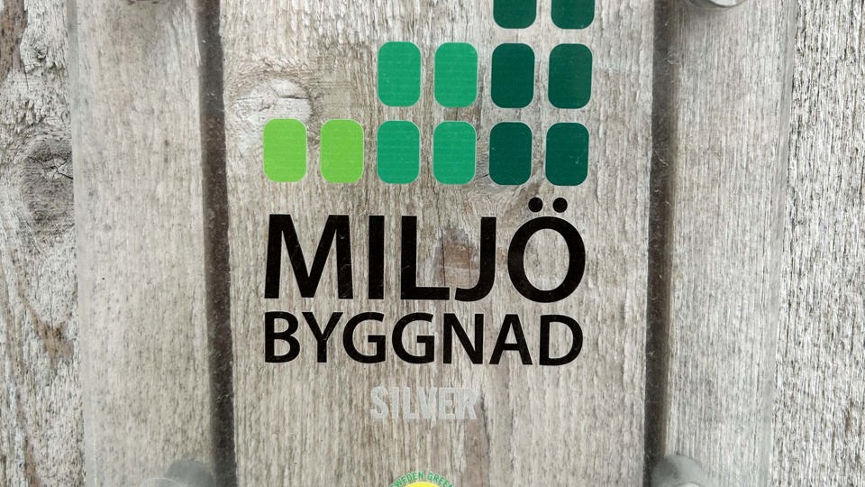Fasadskylt med Miljöbyggnads logotyp.