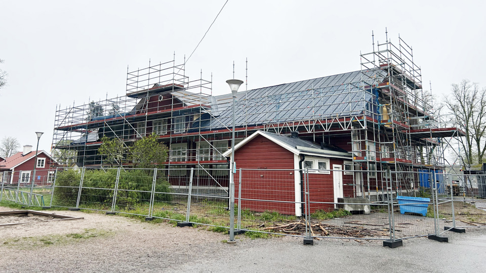 Röd träbyggnad med byggnadsställning.